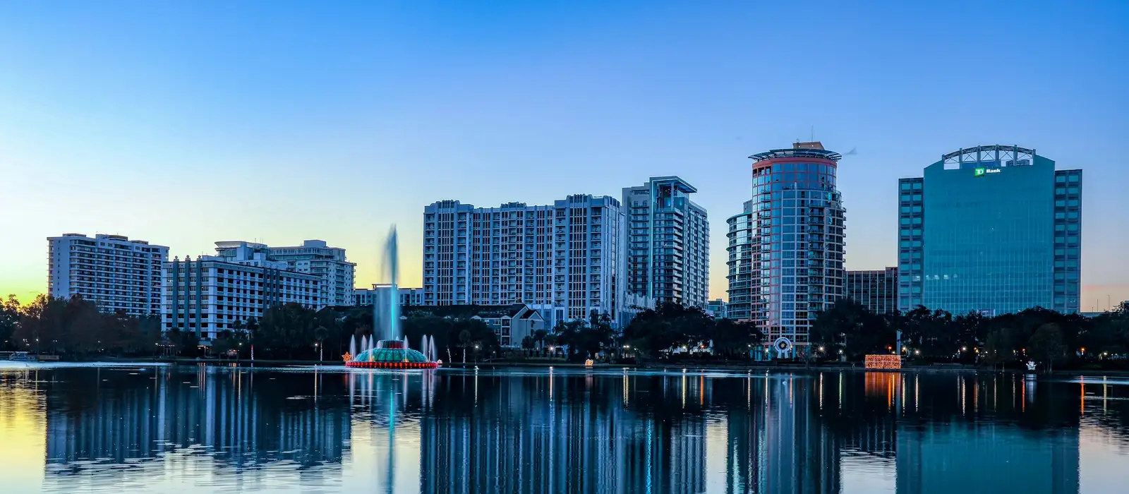 Downtown Orlando office and residential towers reflected in Lake Eola at sunrise