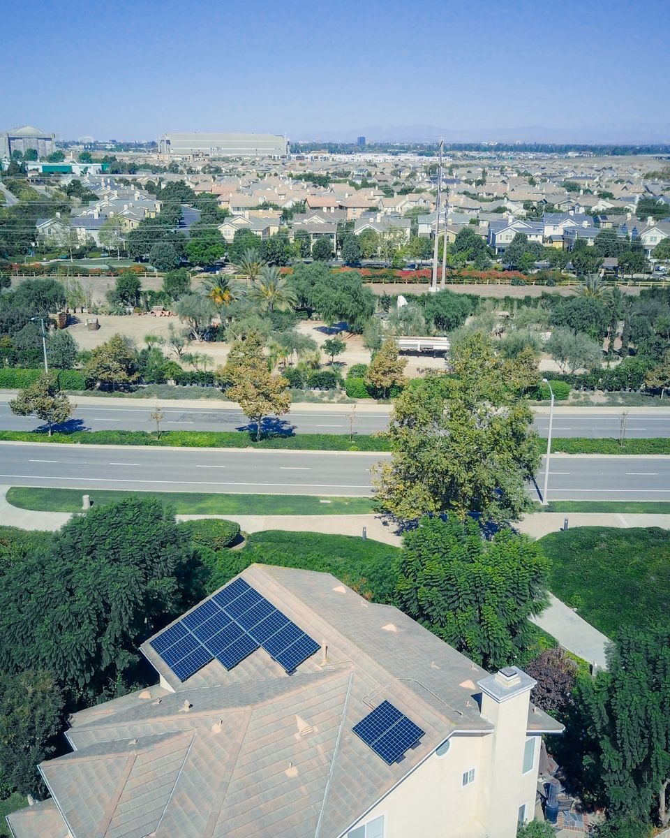 Aerial view of a single family home with rooftop solar panels